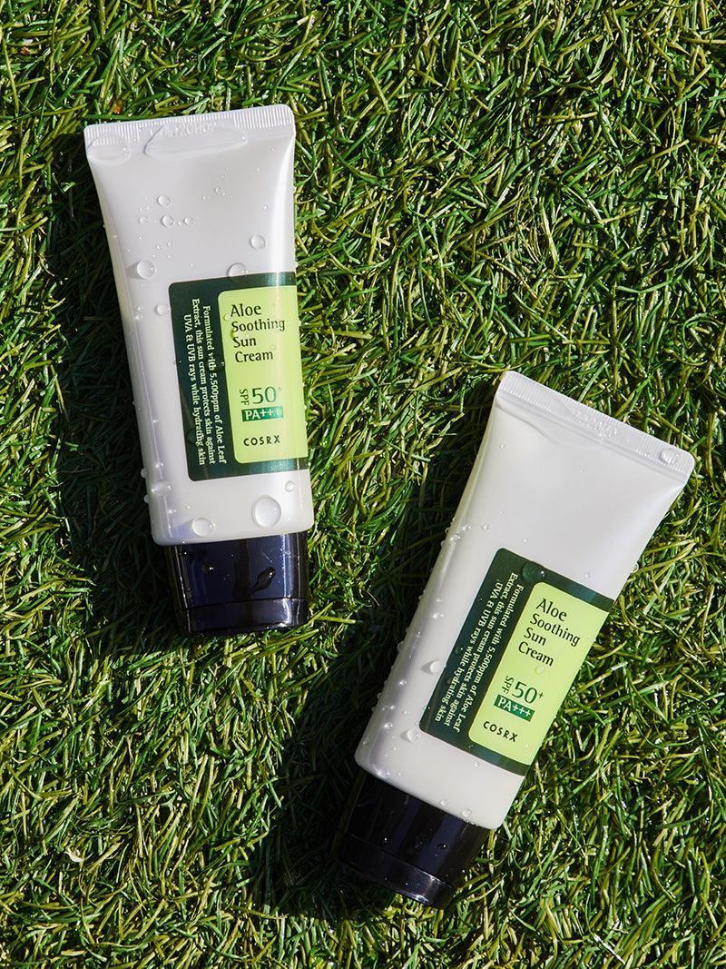 Two tubes of aloe soothing cream on grass