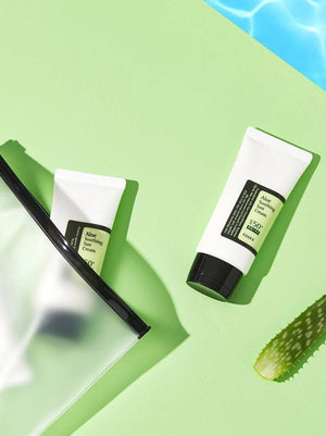 Two tubes of aloe vera cream on a green background with a slice of aloe vera.