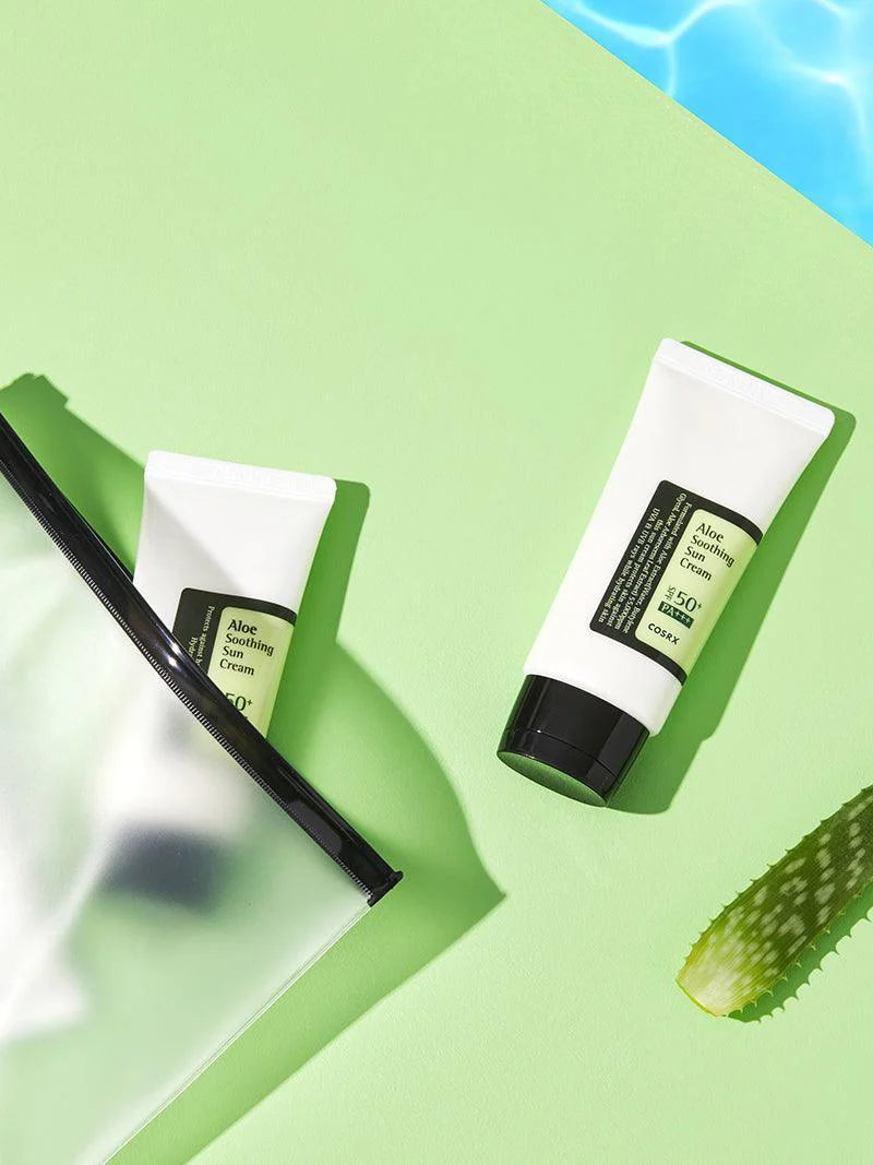 Two tubes of aloe vera cream on a green background with a slice of aloe vera.