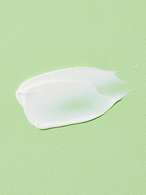 White cream smear on a light green background