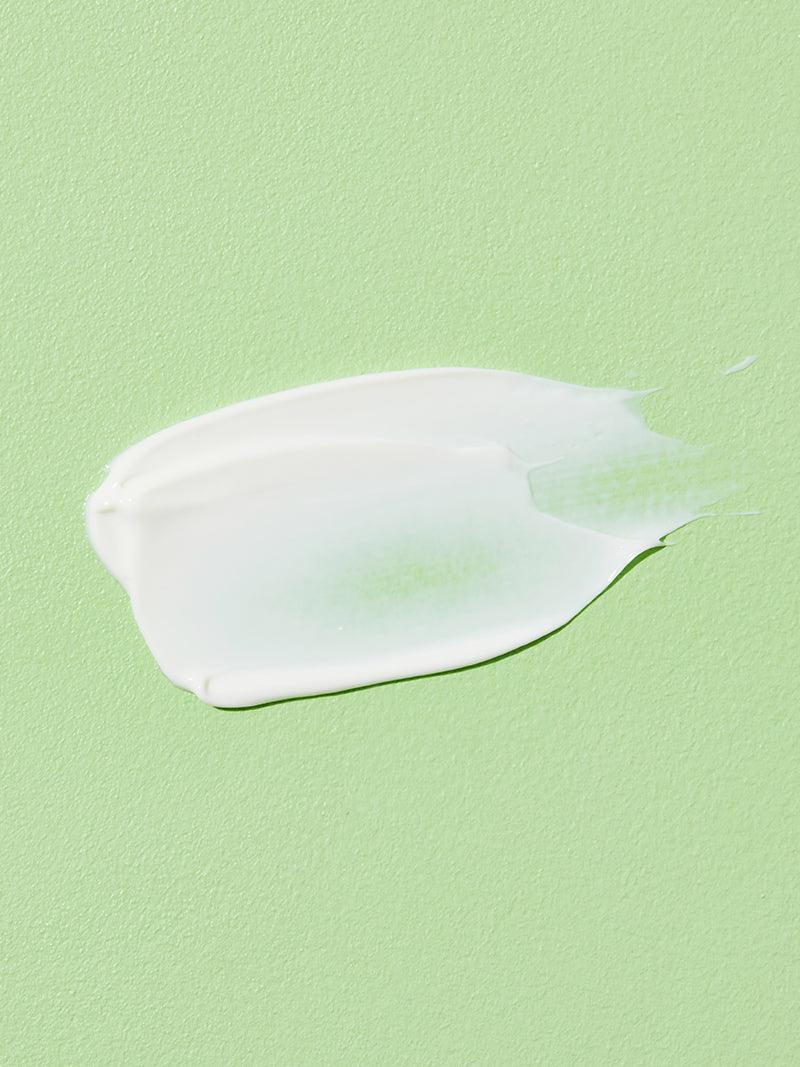 White cream smear on a light green background